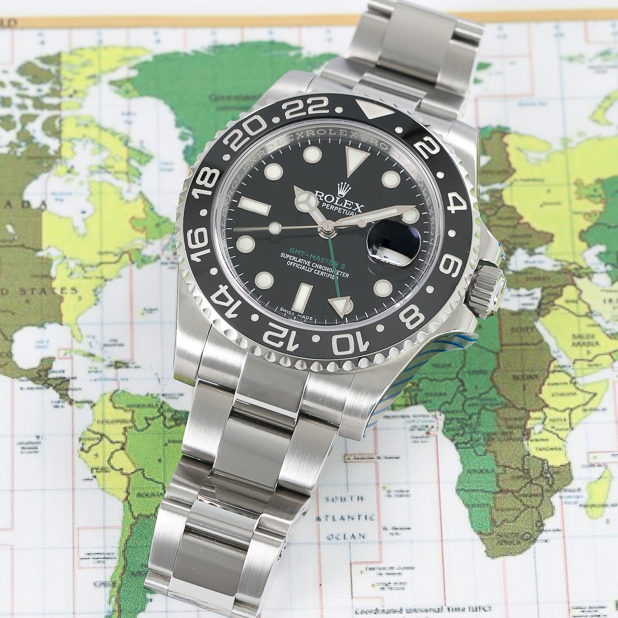 silver-rolex-watch-infront-of-map